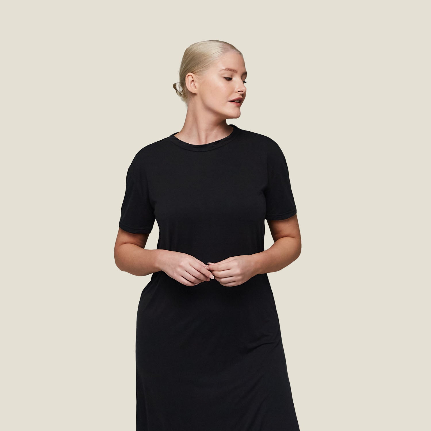 Woman modeling WUKA black T-shirt dress, menopause sleepwear with soft, stretchy jersey fabric and temperature-regulating properties.