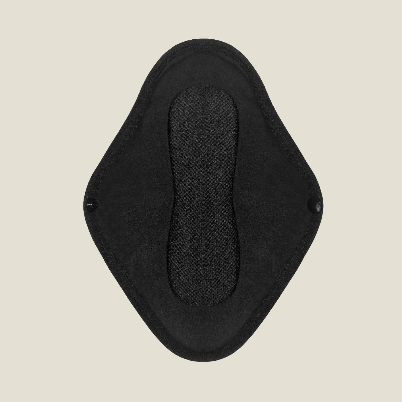 Top view of WUKA x Mooncup reusable pad open flat, revealing black absorbent inner layer and winged design with snap fastening.