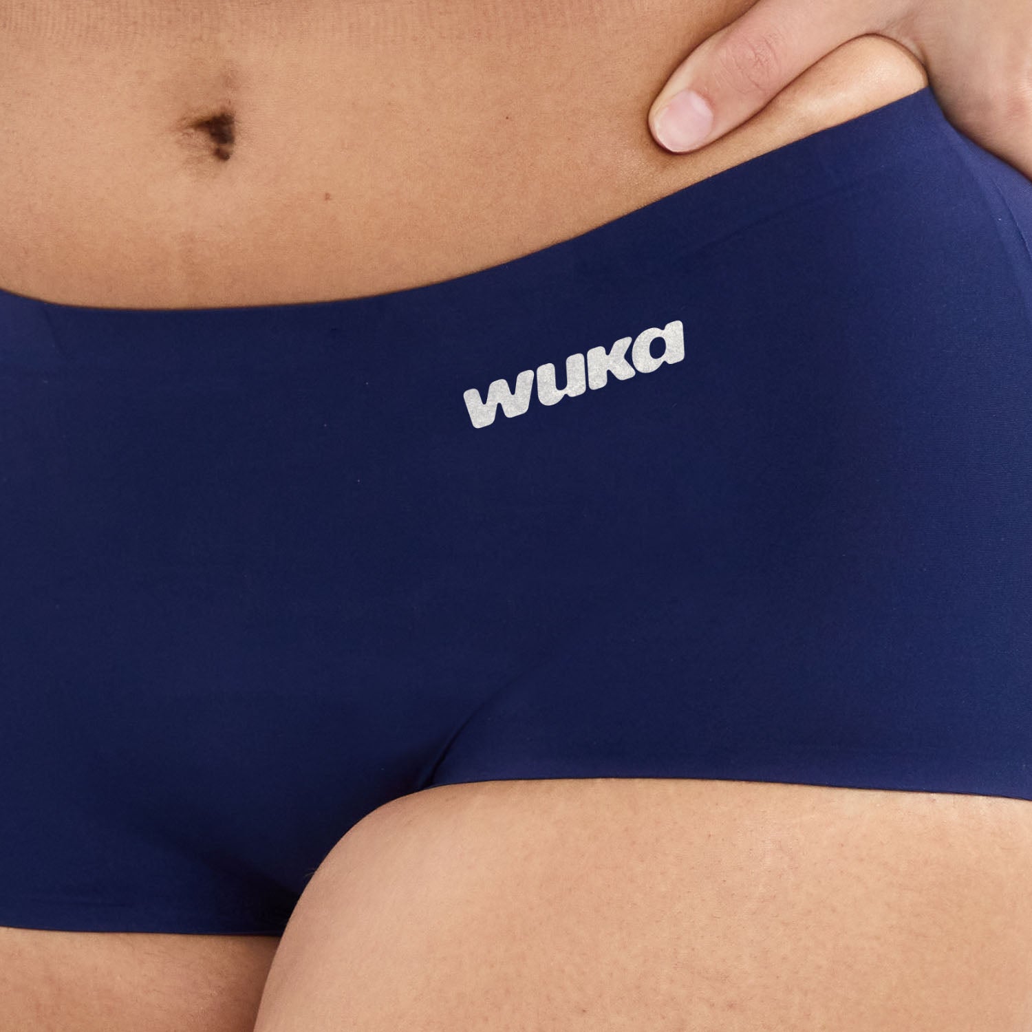 Close-up detail of WUKA logo on navy Teen Stretch™ Boxer Short waistband, highlighting soft, smooth fabric ideal for period wear.