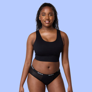 Model wearing WUKA Ultimate heavy flow period underwear in black, promoting buy 3 get 1 free offer on heavy and super heavy period-proof pants for reliable leak protection and comfort.